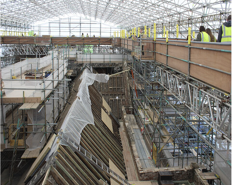 Roof restoration work beneath a large temporary canopy